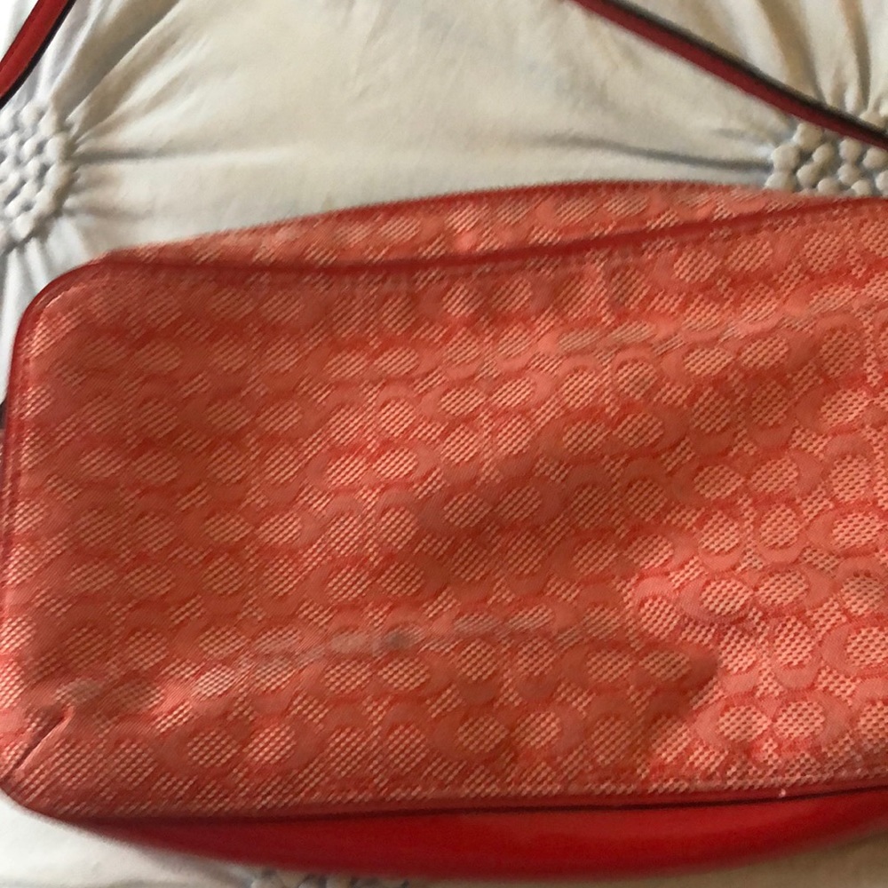 Coach purse, oranges red in color, has strap .